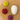 White ceramic Buddha head with colorful silicone lids on a textured surface