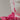 Close-up of a pink substance dripping from a white object onto a red surface.